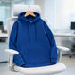 Royal blue pullover hoodie hanging on a white office chair, a color not among the options