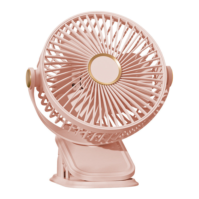 Pink clip fan on a plain background, three blades behind a round grille and gold hub ring