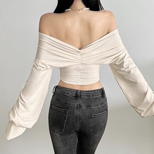Back view of apricot top showing low open V and ruched center seam on the model