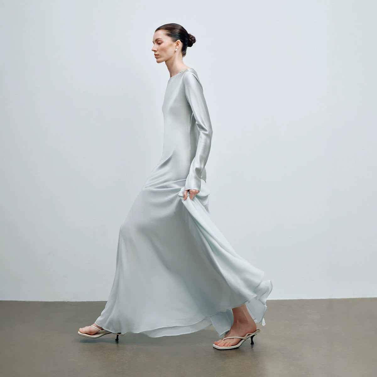 Top down view of the light mint satin long sleeve gown laid out flat