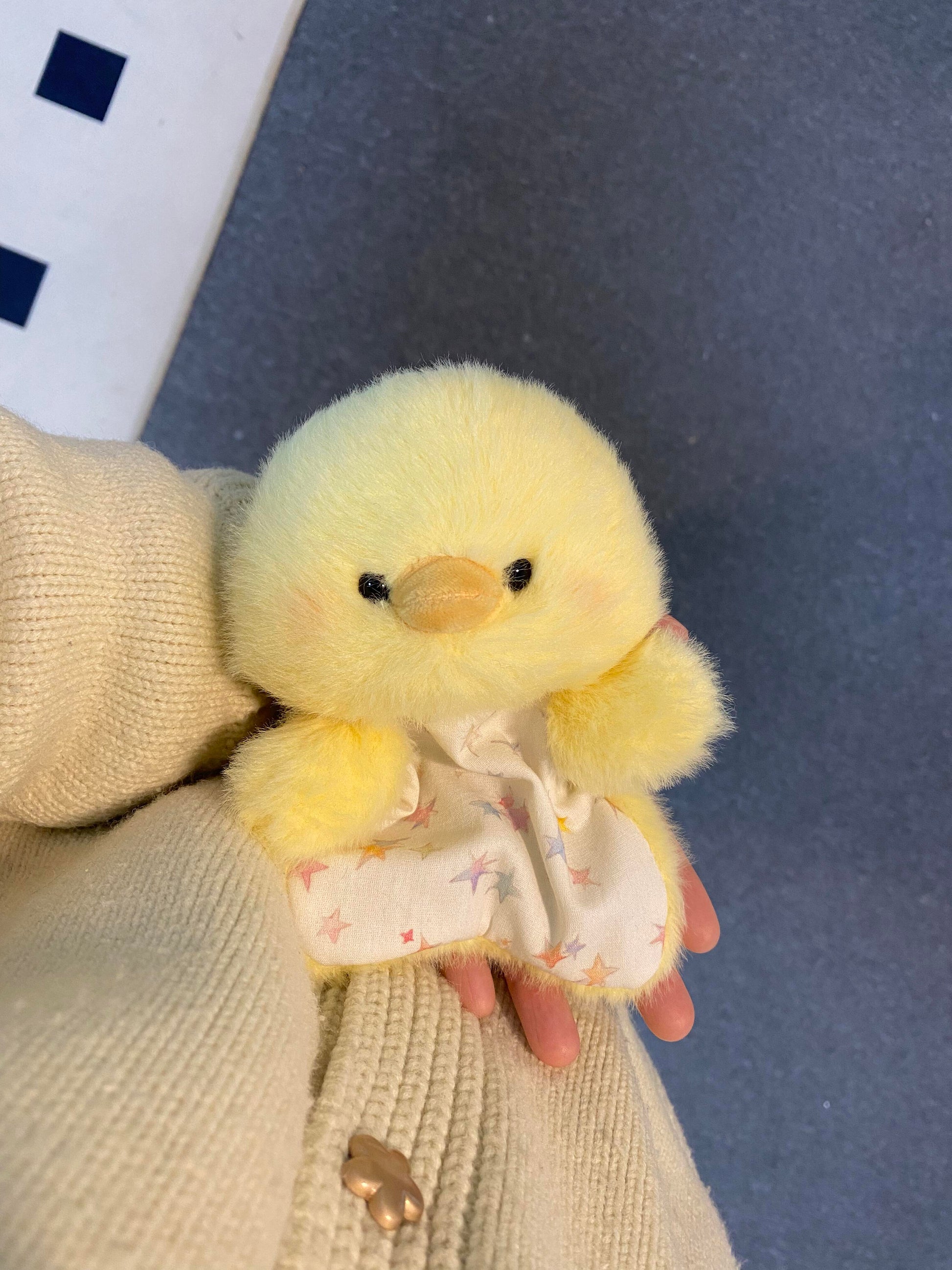 Yellow plush chick squishy bean bag toy in hand, fluffy body and a starry cotton apron
