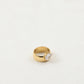 Drop zircon ring shown on a finger for scale next to a slim gold-plated band