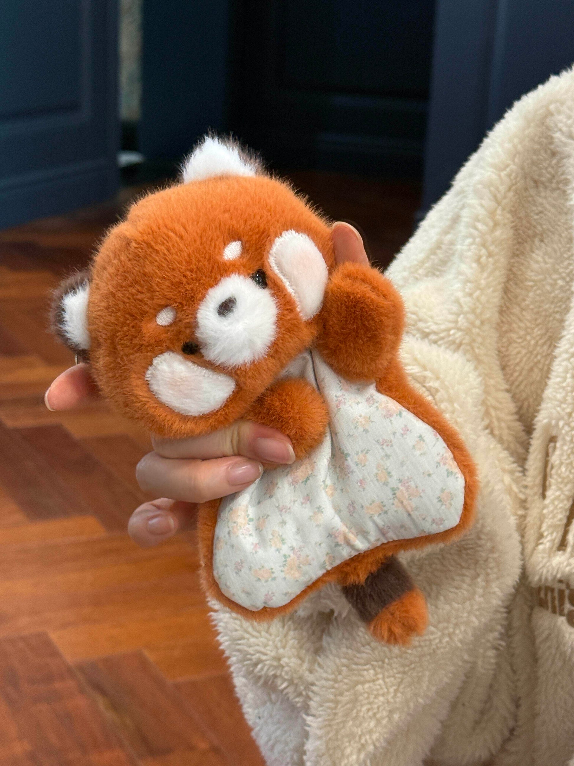 Squishy bean bag plush animal toy in one hand, soft faux fur and a printed cotton apron
