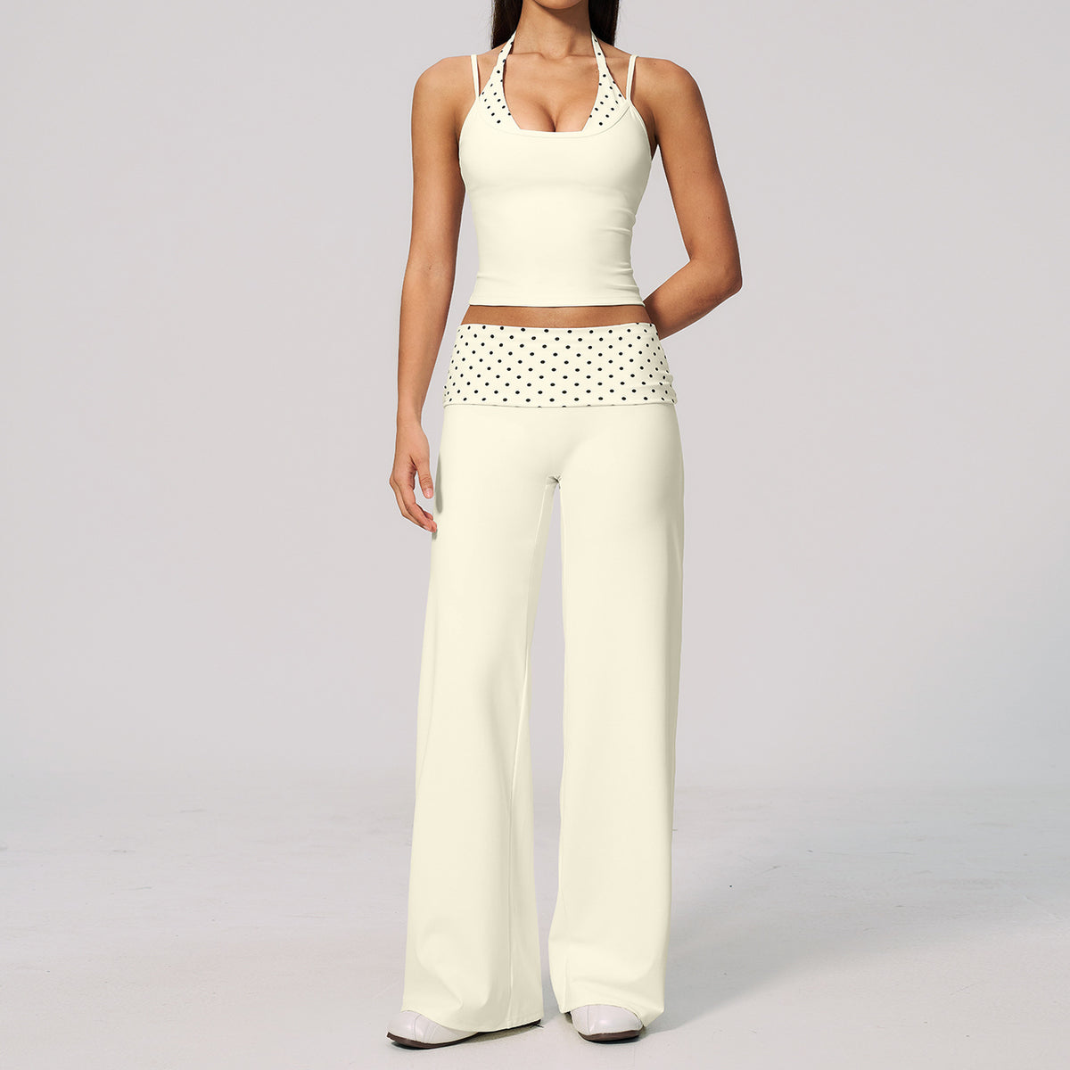 Model in a cropped camisole and wide leg fold over waist pants set, ivory with black polka dots