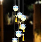 White owl LED figures with blue eyes and golden bells, hanging from a solar lamp head, black housing option