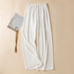 White high waist wide leg linen trousers laid flat with fabric drawstring tie