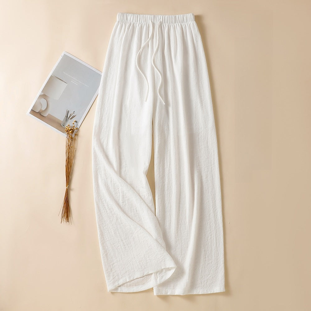White high waist wide leg linen trousers laid flat with fabric drawstring tie