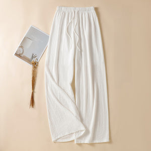 White high waist wide leg linen trousers laid flat with fabric drawstring tie