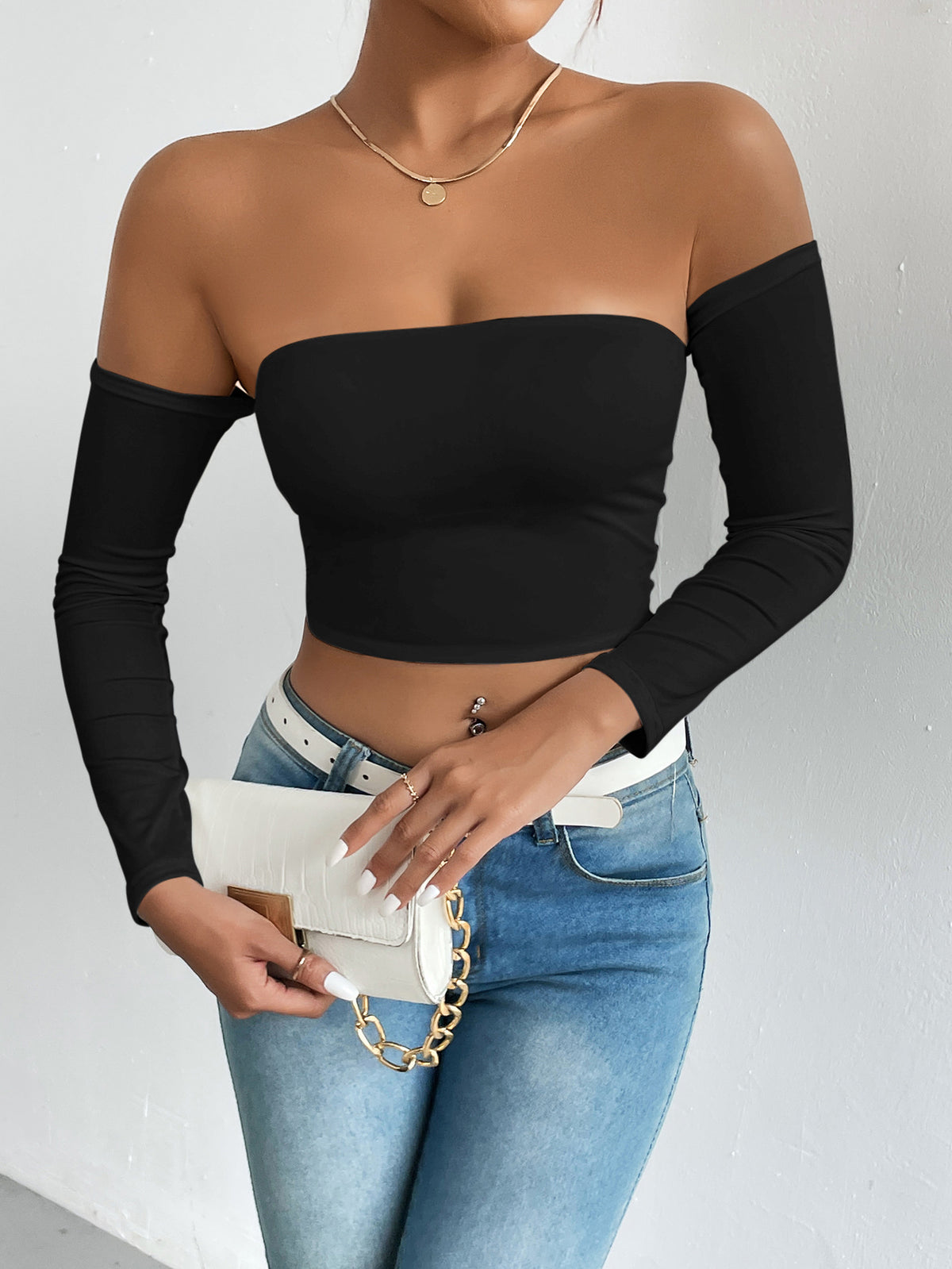 Close view of the bardot neckline and bare collarbone on a black off shoulder crop top