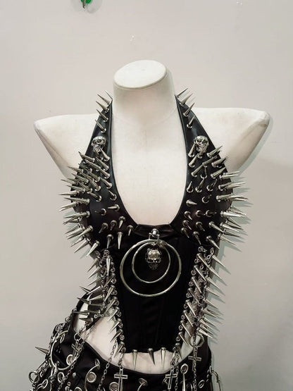 Black faux leather punk vest with silver spikes and skull O-ring pendant on mannequin, front view