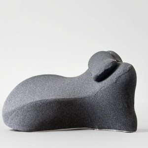 Deep gray contoured back cushion seen from the side with the small neck roll seated in the valley
