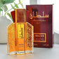 Sultan eau de toilette bottle and burgundy gift carton on a desk beside a green plant by a window