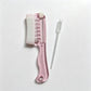Pink scalp liquid comb with white soft rubber cover and a dropper pipette on a light surface, OPP bag option