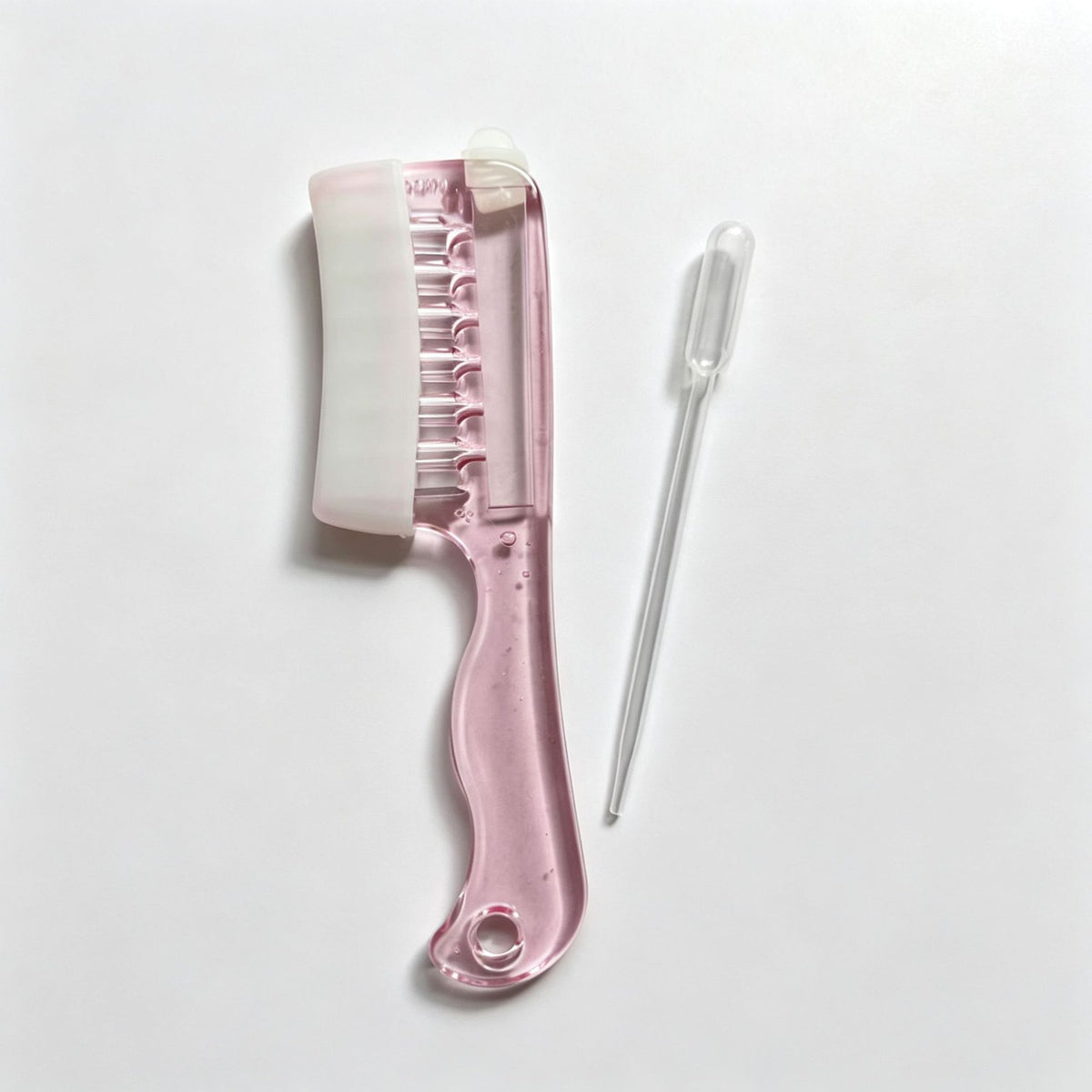 Pink scalp liquid comb with white soft rubber cover and a dropper pipette on a light surface, OPP bag option