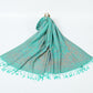 Aqua green paisley jacquard scarf spread on a white background with twisted aqua tassel fringe