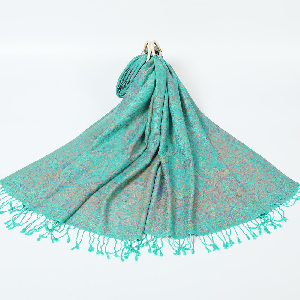Aqua green paisley jacquard scarf spread on a white background with twisted aqua tassel fringe