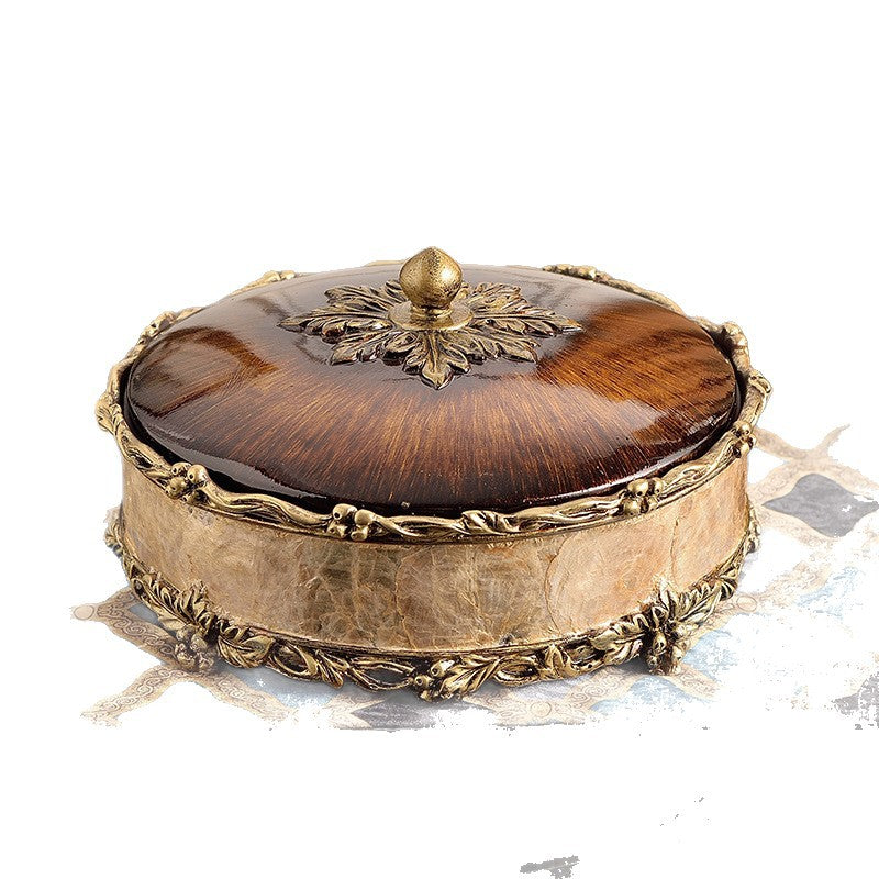 European style resin display piece with pearl shell inlay and gilt scrollwork on a tabletop scene