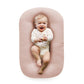 Padded baby lounger nest in soft studio lighting on a plain backdrop