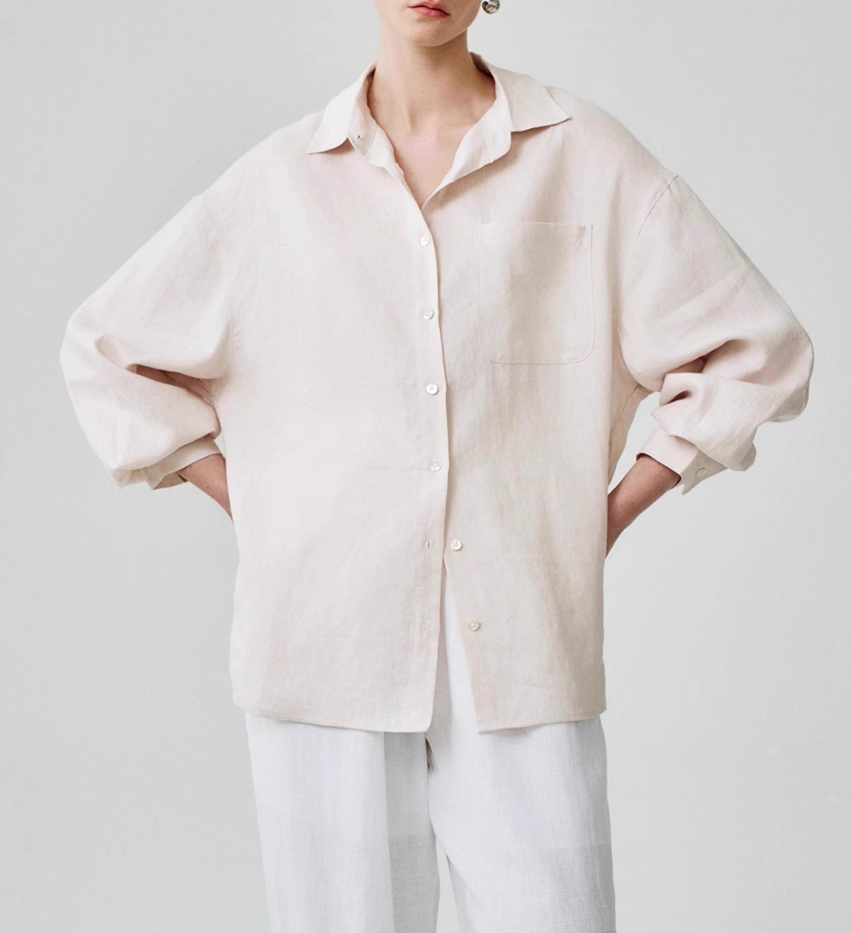 Black linen shirt with lapel collar buttoned to the chest