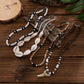 Four strand shell and disc bead necklace set laid out on dark wood with the tooth pendant at the front