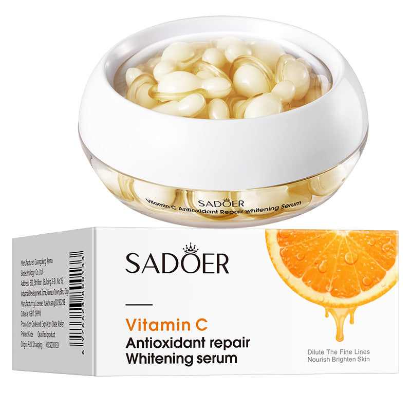Pale vitamin C essence capsules in a jar next to the vitamin C box