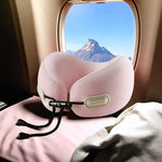 Spring powder pink U-shaped memory foam travel neck pillow resting on an airplane seat