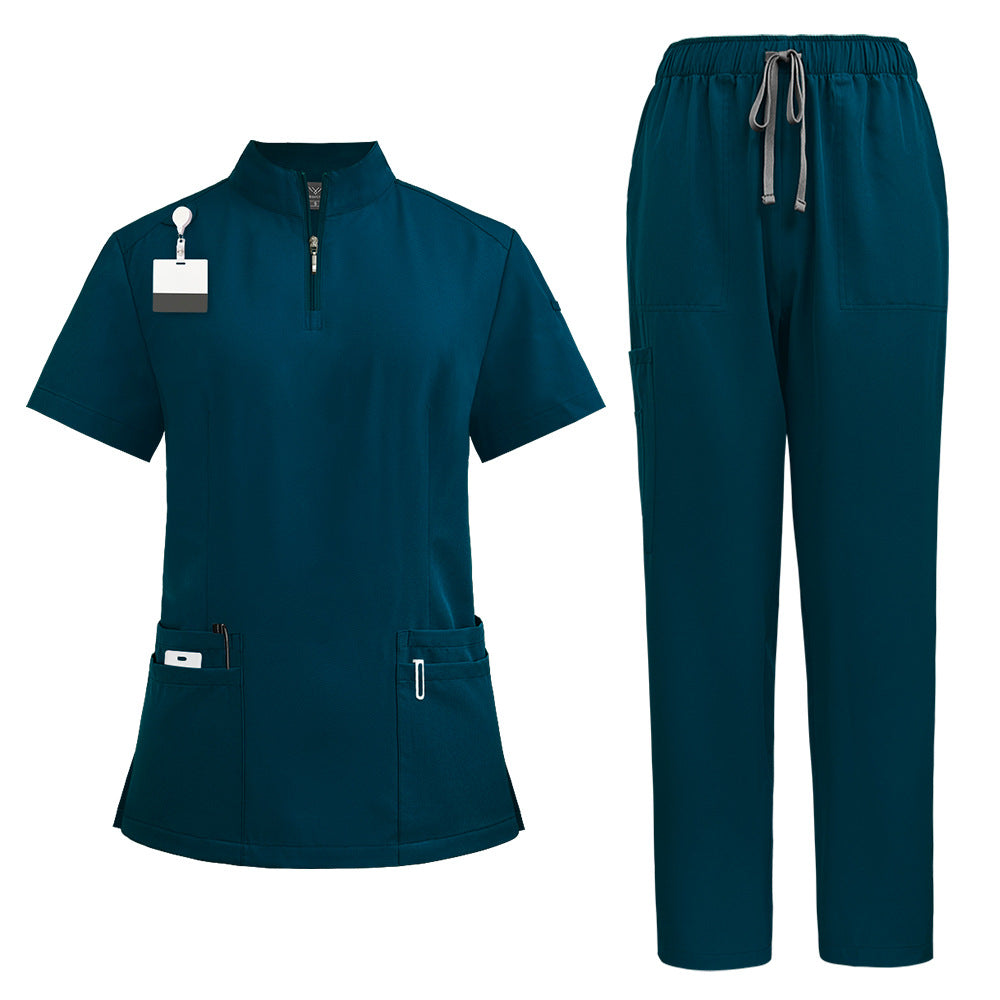 Womens scrub top in Caribbean blue shown flat to display the stand collar, quarter zip and hip pockets