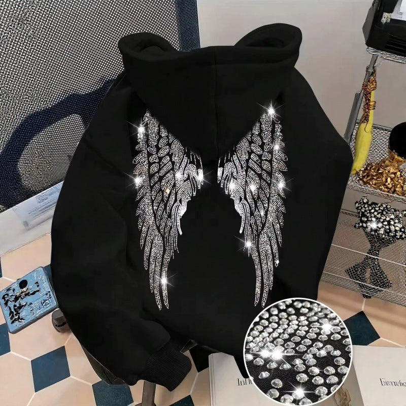 Black hoodie back with sparkling rhinestone wings on a chair, with a stone close-up