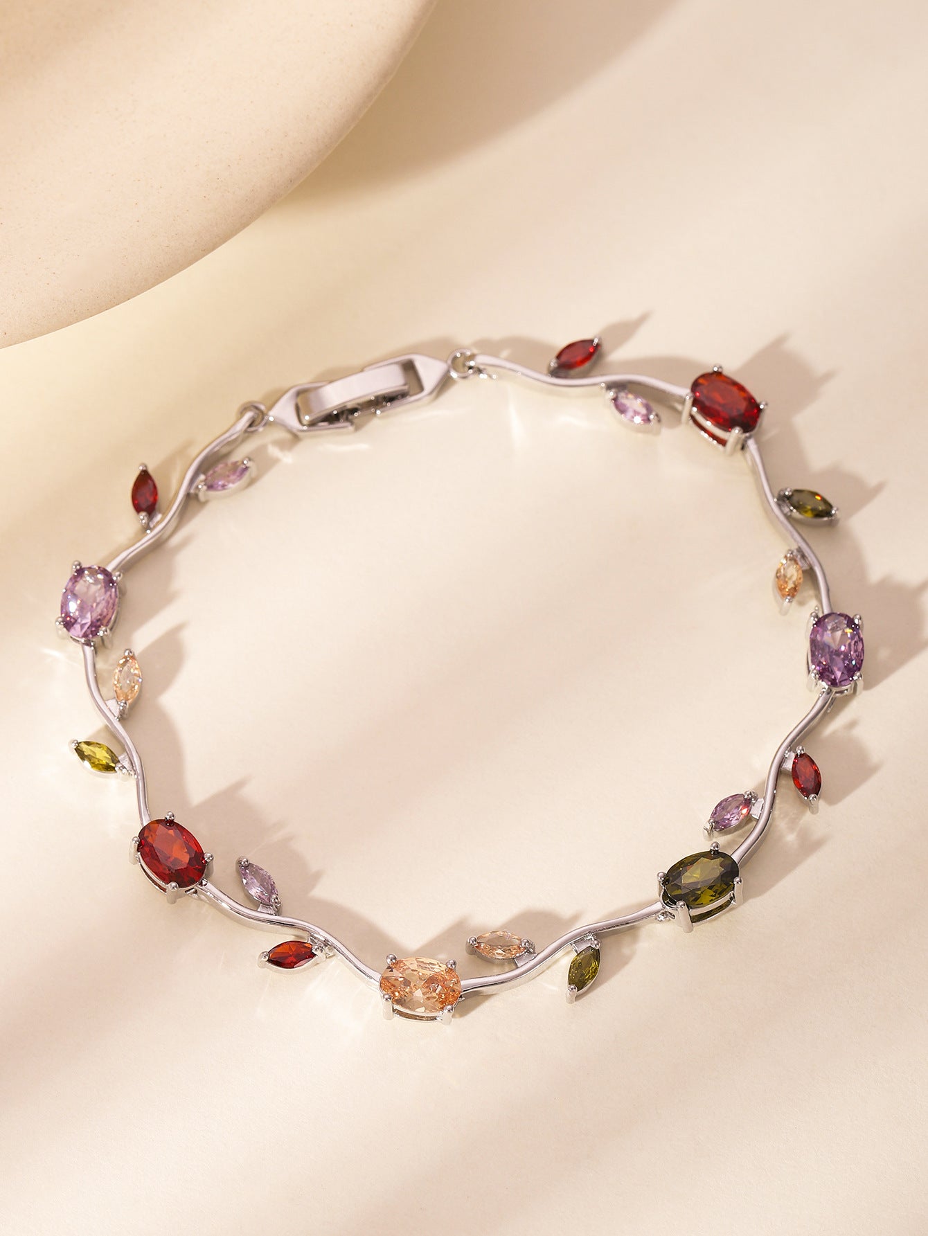 Zircon gold leaf bracelet held in a hand to show its slim scale