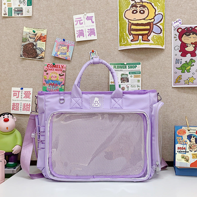Clear window nylon shoulder bag shown on a desk with top handles and long strap