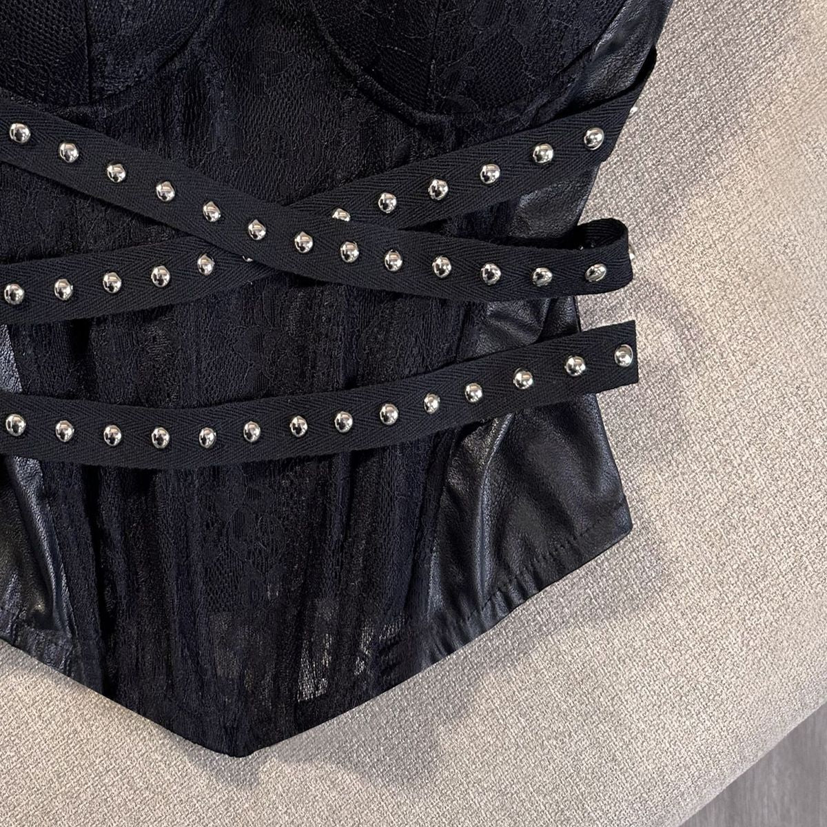 Molded sweetheart cups of the strapless black bustier over a lace textured boned body