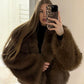 Coffee brown long pile vegan fur short jacket worn open over a black top
