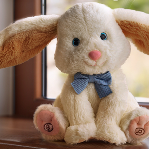 Electric plush rabbit toy sitting on a wooden windowsill with long floppy apricot ears