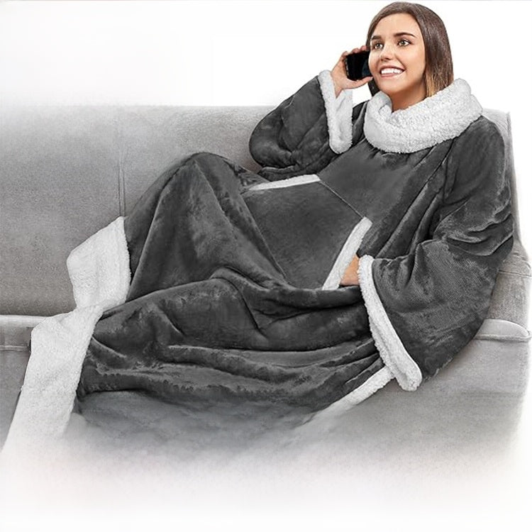 Woman on the phone on a sofa wearing a gray sleeved blanket with a sherpa collar and wide cuffs