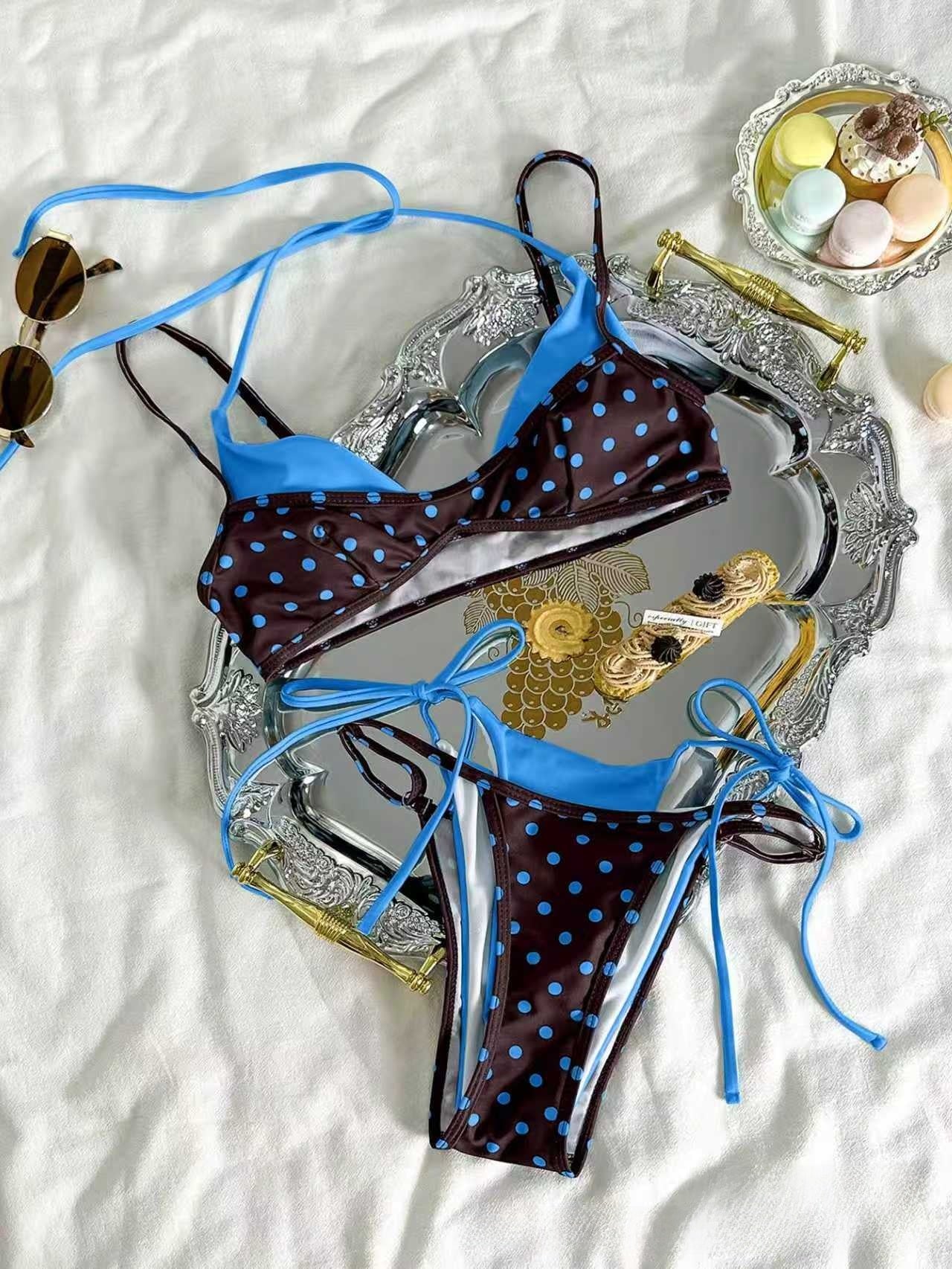 Red polka dot bikini worn by a wall, padded triangle cups and knotted tie side bottoms