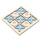 Wooden tic tac toe board with blue crosses and white rings set in the sunken grid, angled view