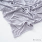 Corner of the modal cotton headscarf wrap showing the neat rolled hem and flat solid color