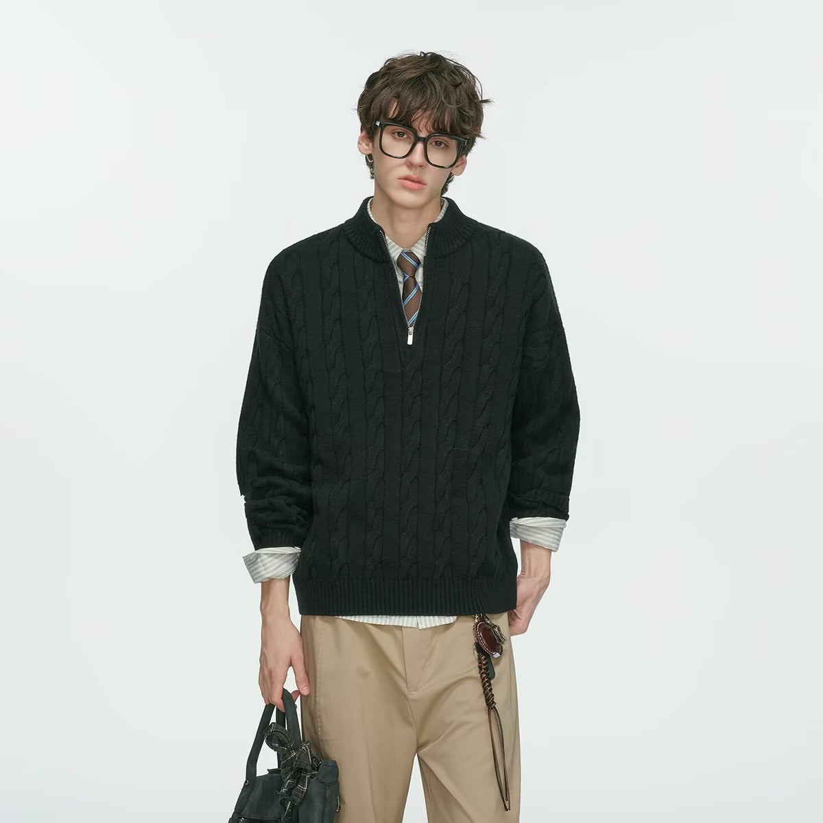 Black half zip cable knit sweater with a striped tie and beige trousers on a male model, fourth black option photo