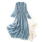 Lifestyle shot of the silk slip dress in a corner cafe at dusk