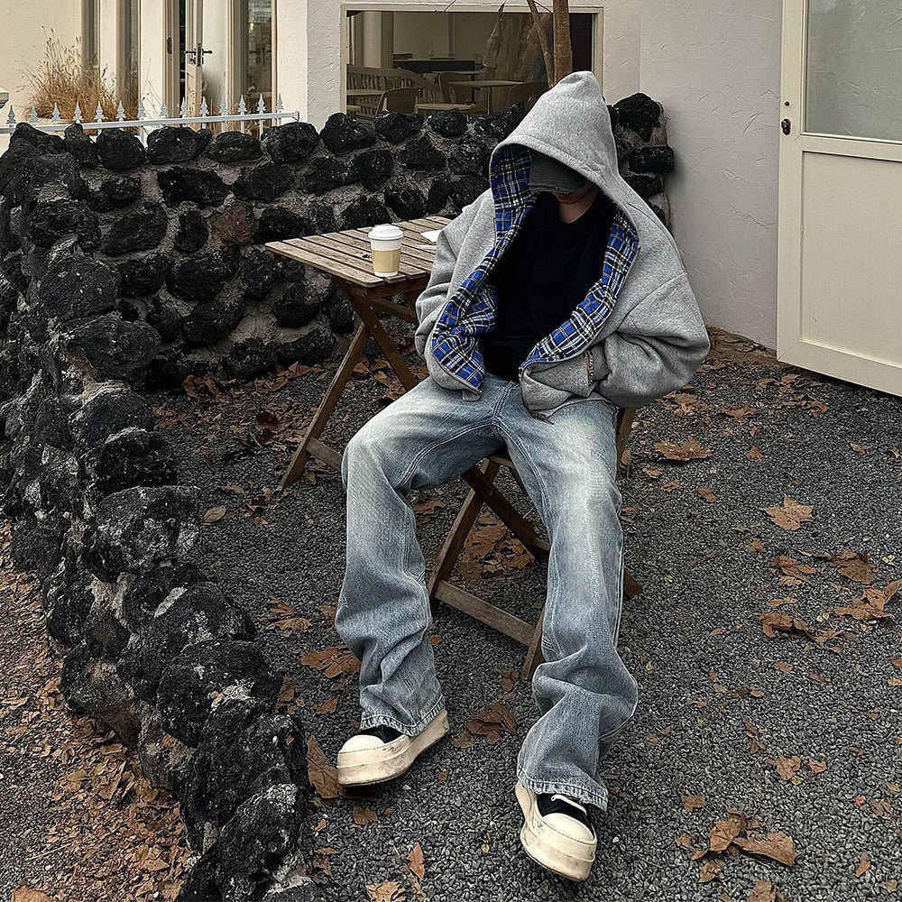 Model in the grey reversible zip hooded sweatshirt, solid grey outer over a blue plaid reverse