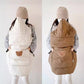 Off-white and coffee quilted baby capes shown side by side on a carrier