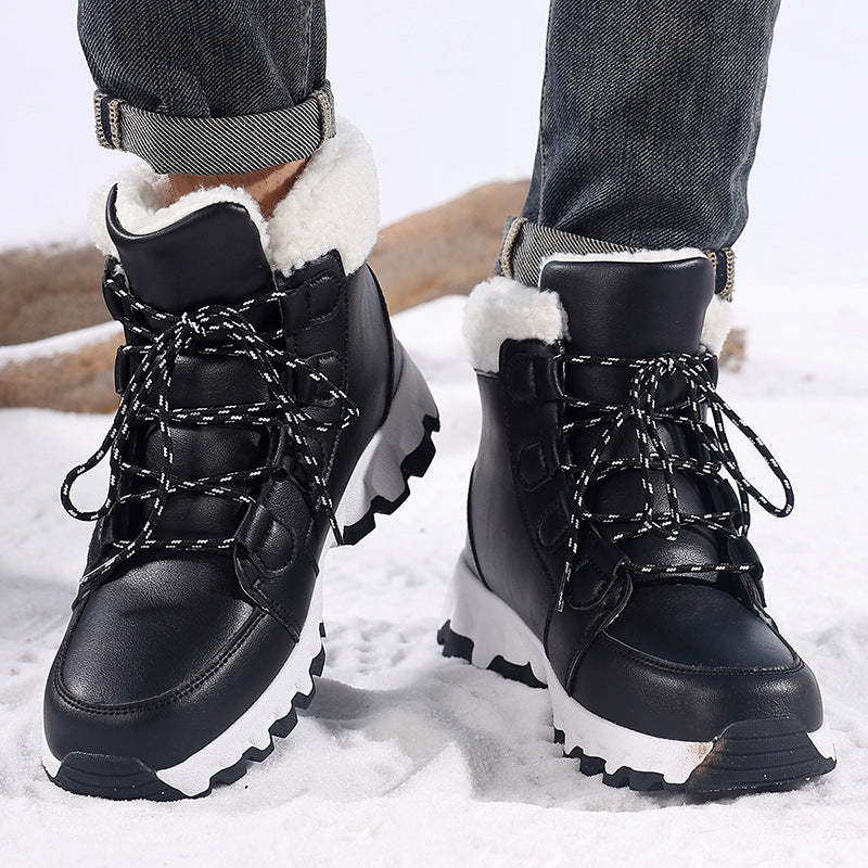 Pair of black winter boots in snow showing the deep zigzag lugs of the outsole
