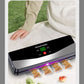 Cordless food vacuum sealer on a white cloth outdoors sealing four small portioned snack bags