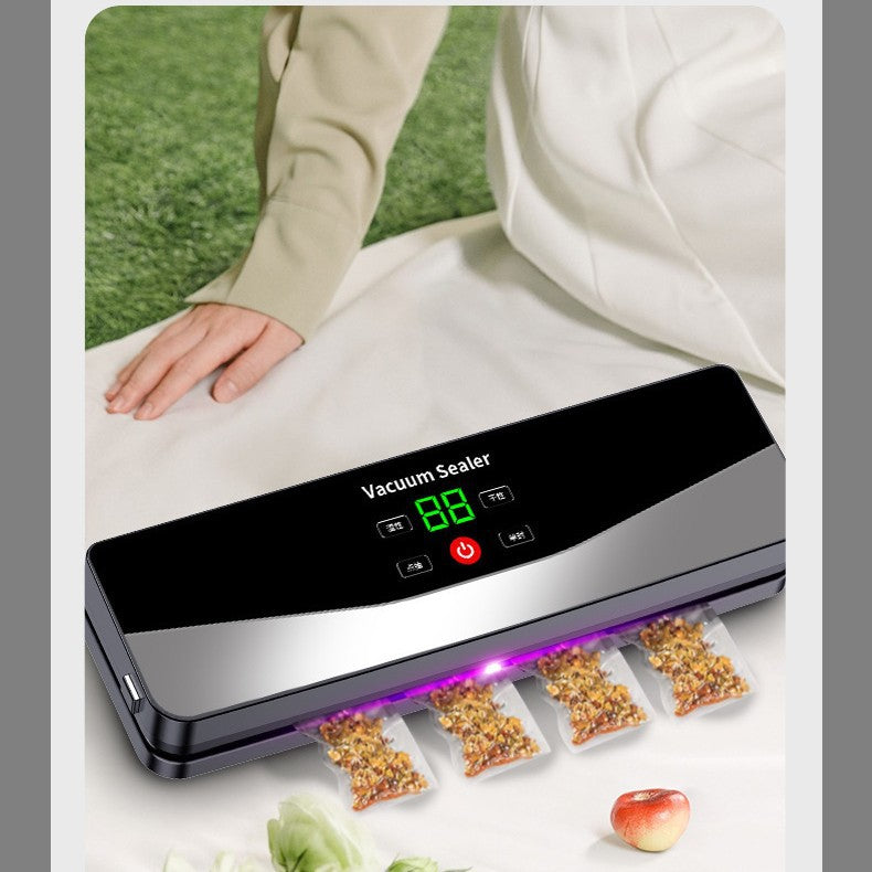 Cordless food vacuum sealer on a white cloth outdoors sealing four small portioned snack bags