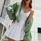 Detail of the raised three dimensional white knitted flowers on the floral knit cardigan