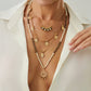 Gold layered bohemian necklace with a sun pendant and coin charms worn