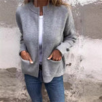 Gray zip-front cardigan with round neck and two patch pockets, worn over a white top and jeans