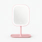 Pink square LED makeup mirror on a pink tray base on a white background