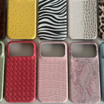 Assorted half-cover phone cases in yellow ostrich, zebra, white crocodile, leopard, woven red and pink prints on grey