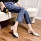 Black and beige pointed-toe mules with gold-tone studded straps